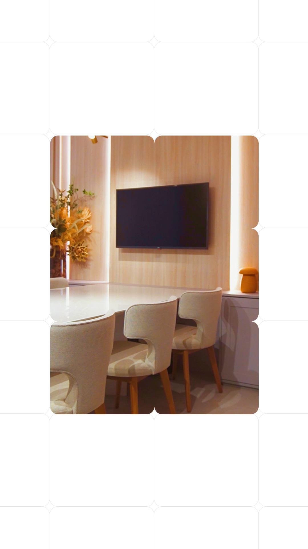 Sala de reuniões com painel madeirado, iluminação integrada e mesa com cadeiras